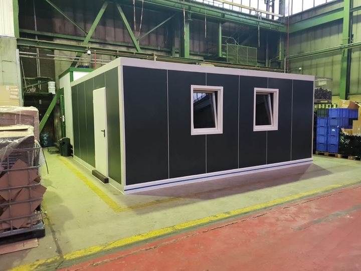 Von Frigano realisierter Bürocontainer aus Isolierpaneelen in Anthrazit, in der Werkhalle