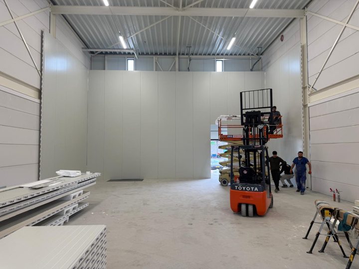Montage der Kühlhaus-Wände mit Hubarbeitsbühne und Monteuren