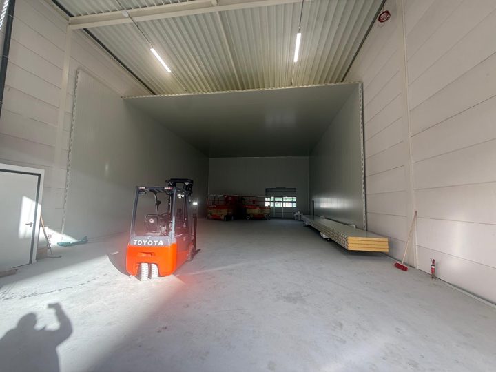 Langer Kühlhaus-Innenraum mit Deckenbeleuchtung und Gabelstapler